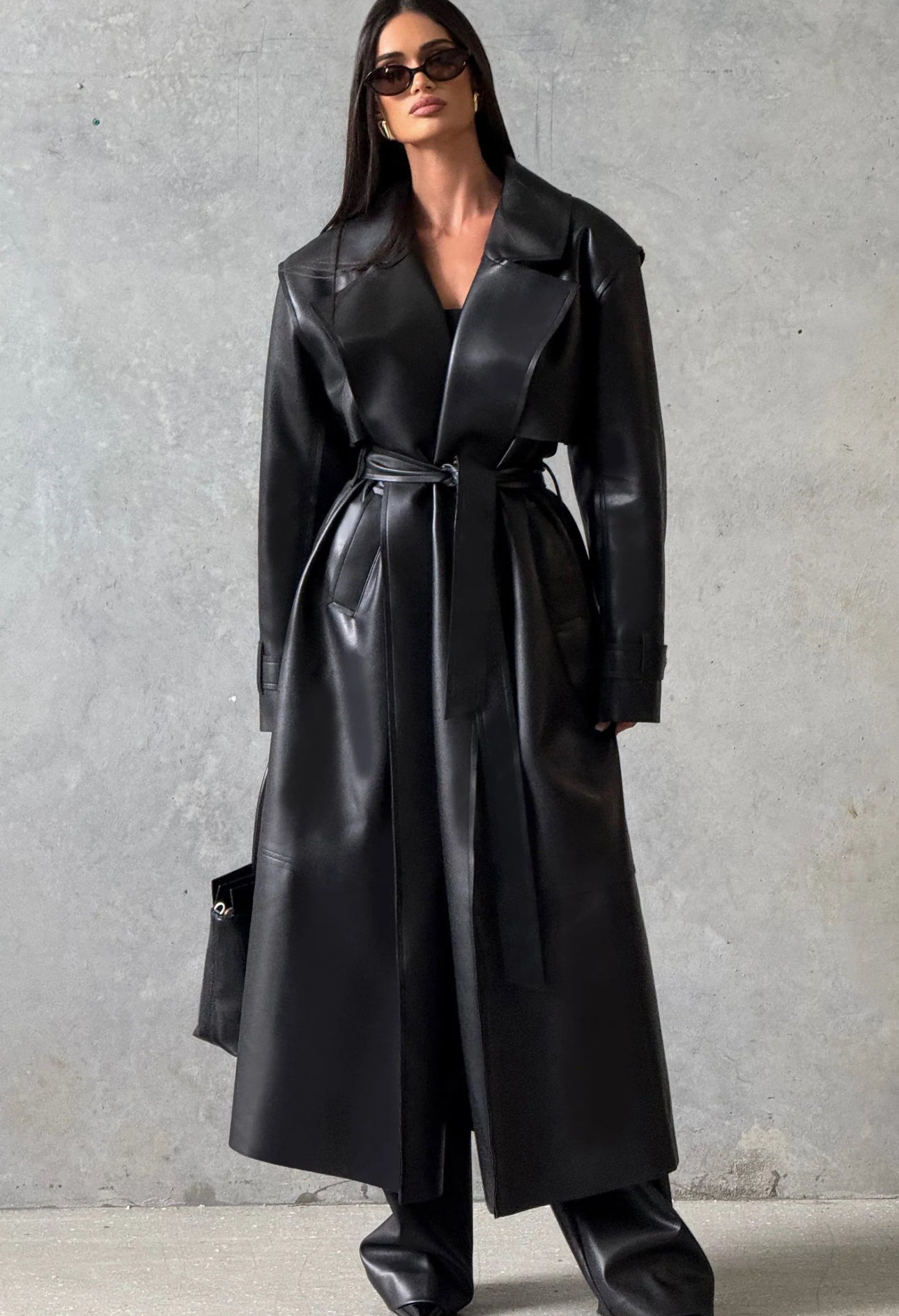 Trench ANITA in eco-pelle con cintura Un look deciso e sofisticato, perfetto per chi ama uno stile contemporaneo e audace.