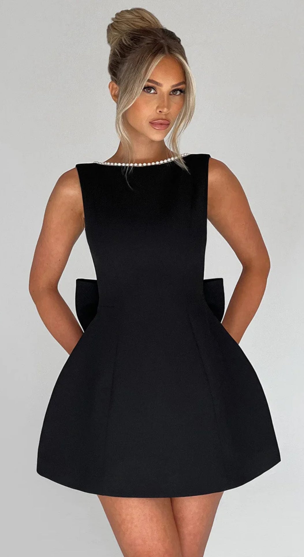 Mini Dress ALESSIA caratterizzato da un design sofisticato e femminile. Presenta una scollatura profonda sulla schiena, impreziosita da un bordo di perline che segue il profilo delle spalline e il décolleté posteriore…