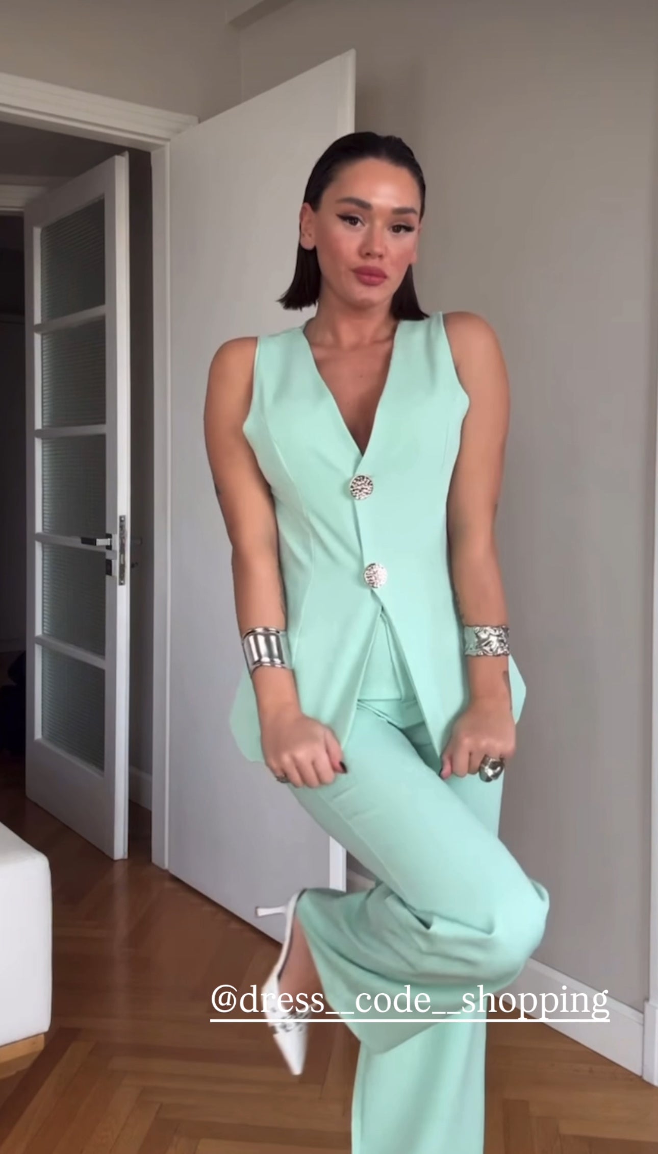 Tailleur ESTER elegante composto da un gilet smanicato e un paio di pantaloni a gamba larga Il gilet presenta due bottoni decorativi centrali dal design gioiello. I pantaloni sono a vita alta, con una vestibilità morbida e fluida