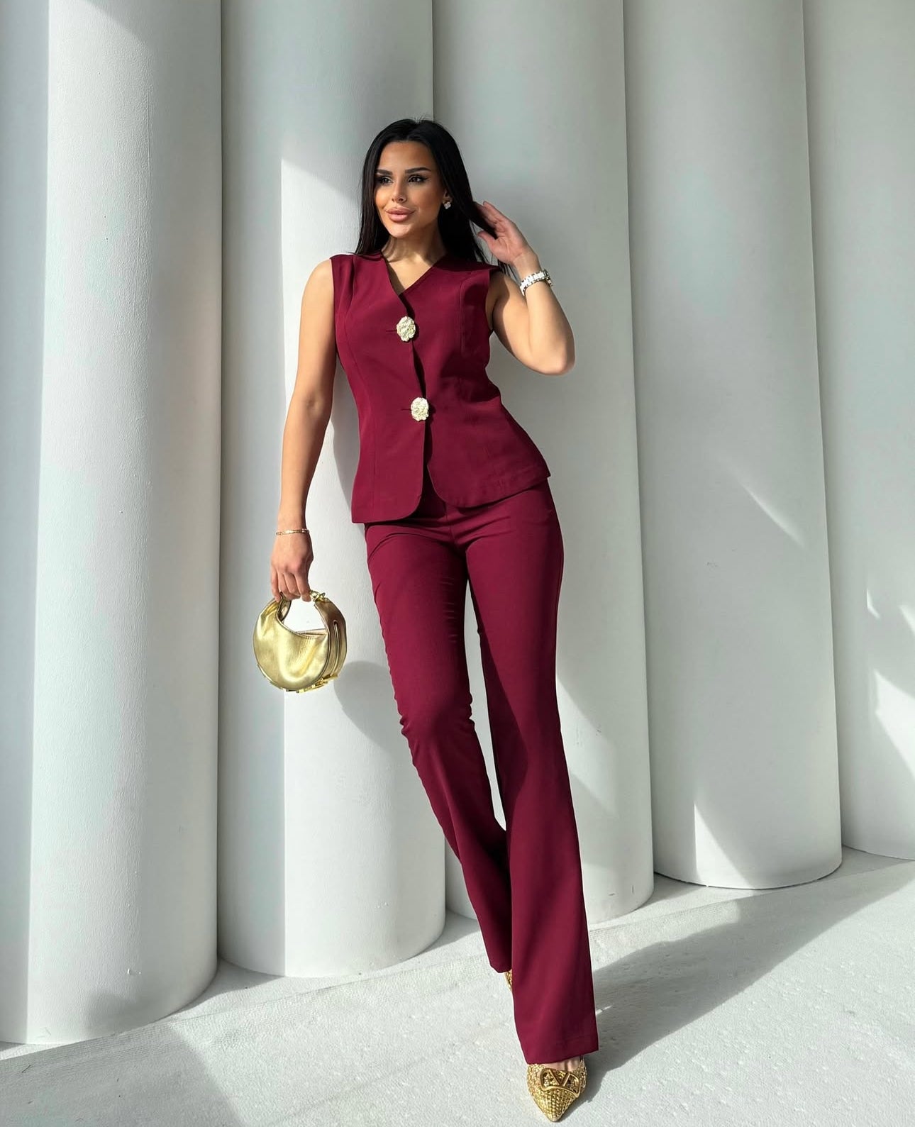 Set cord PERLA elegante composto da un gilet smanicato e un paio di pantaloni a gamba larga Il gilet presenta due bottoni decorativi centrali dal design gioiello. I pantaloni sono a vita alta, con una vestibilità morbida e fluida