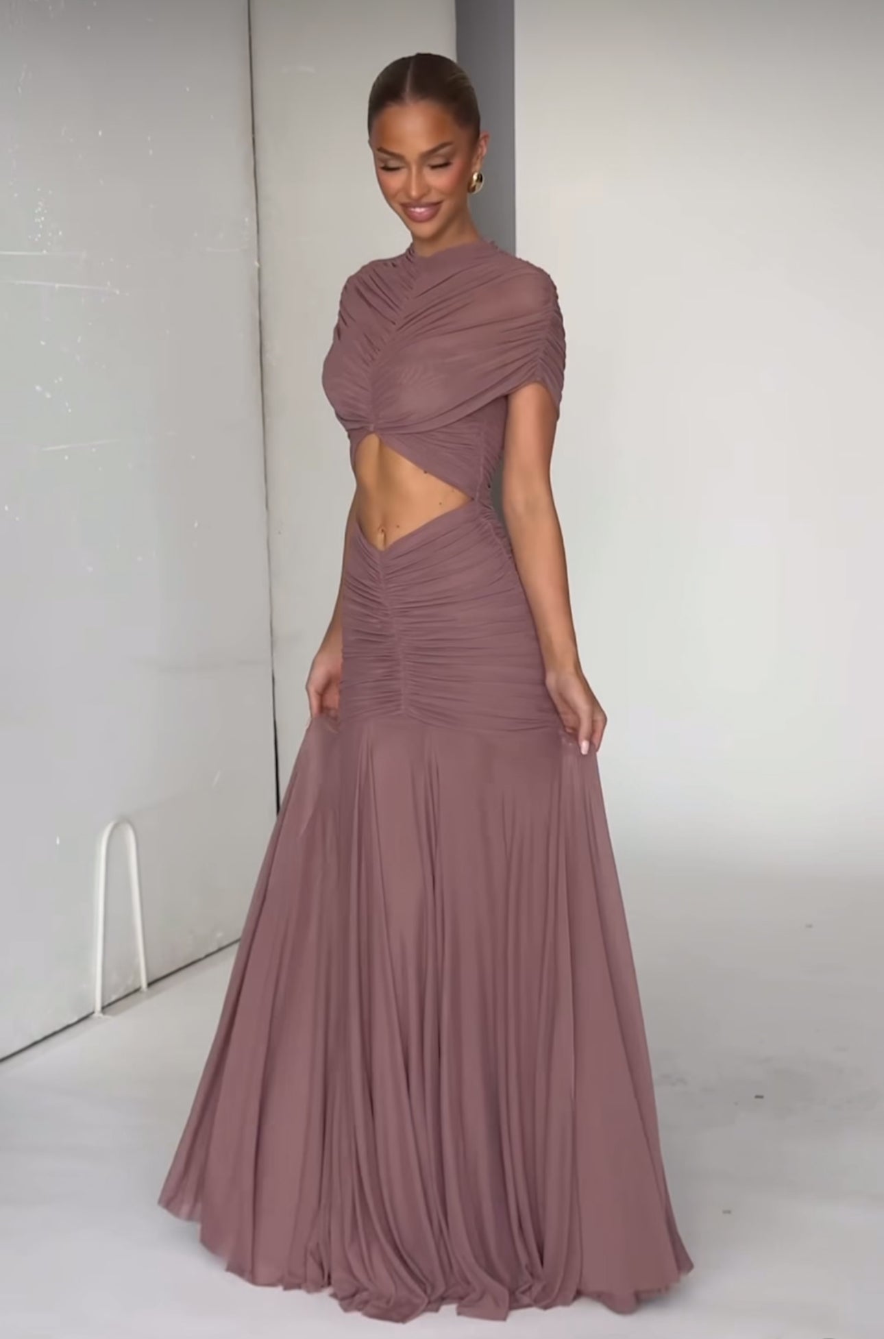 Abito Martina lungo elegante realizzato in tessuto leggero e drappeggiato che valorizza la silhouette. Design sofisticato con top incrociato effetto cut-out e gonna fluida a sirena.