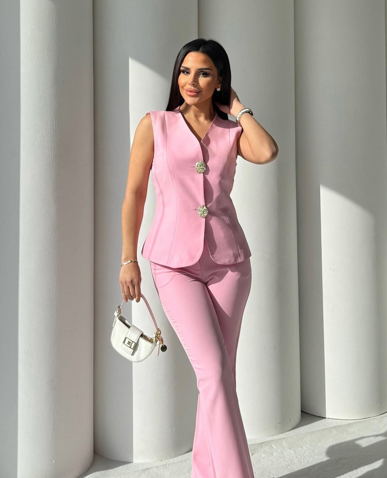 Set cord PERLA elegante composto da un gilet smanicato e un paio di pantaloni a gamba larga Il gilet presenta due bottoni decorativi centrali dal design gioiello. I pantaloni sono a vita alta, con una vestibilità morbida e fluida