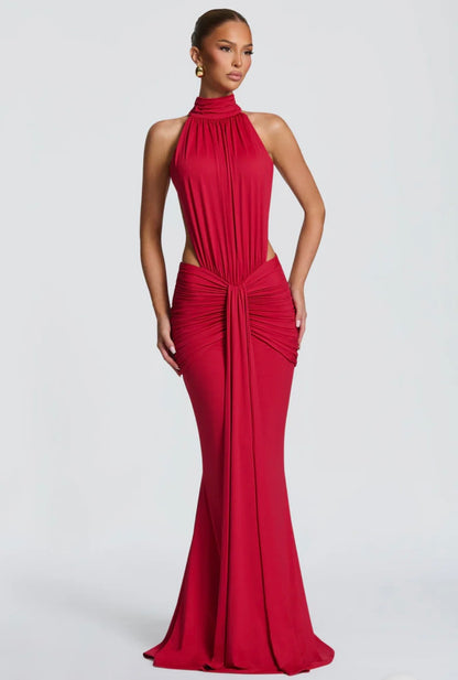 Abito Sofia Caratterizzato da una silhouette a sirena che valorizza le forme, questo modello unisce un sofisticato collo alto a un audace gioco di drappeggi e intagli cut-out sui fianchi.