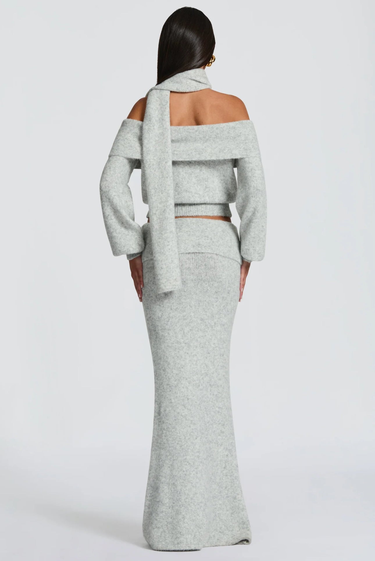 Set BIANCA composto da maglia off-shoulder e gonna lunga a sirena. Realizzato in morbida maglia calda, avvolge la silhouette con eleganza e comfort. Il design con collo ad anello e spalle scoperte aggiunge un tocco sofisticato e sensuale