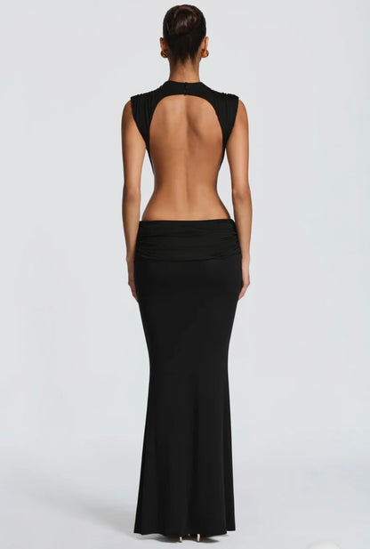 Abito Sahara maxi aderente in elegante rosa terracotta con design cut-out laterale che scolpisce la silhouette. Il collo alto crea un raffinato contrasto con le ampie aperture sui fianchi e la schiena scoperta, per un effetto sensuale ma sofisticato.