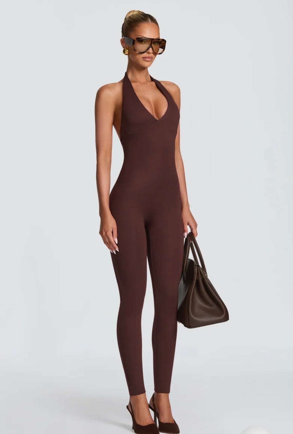 Tuta Intera Aderente Allacciata al Collo (Halter Jumpsuit) ultra-aderente con scollo all'americana e schiena scoperta. Un capo versatile e modellante che unisce eleganza minimale e sensualità, perfetto per serate ed eventi speciali.