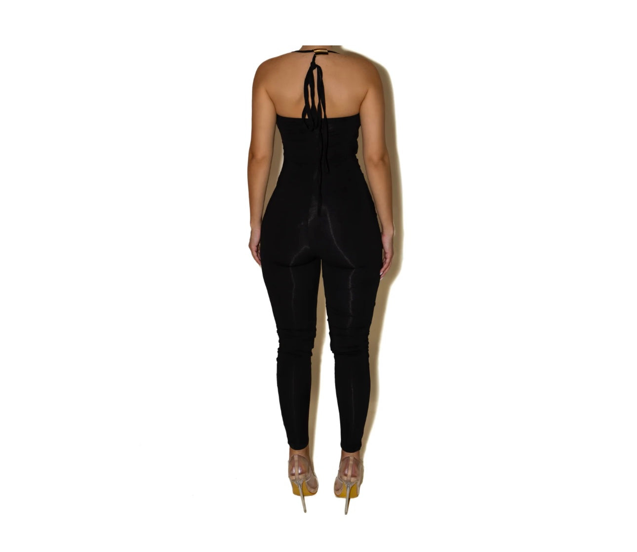 Jumpsuite SCARLETT Un look audace e raffinato che valorizza la silhouette con un design cut-out e dettagli metallici. Il top con inserti dorati e il pantalone a vita alta creano un equilibrio perfetto tra sensualità e stile moderno.