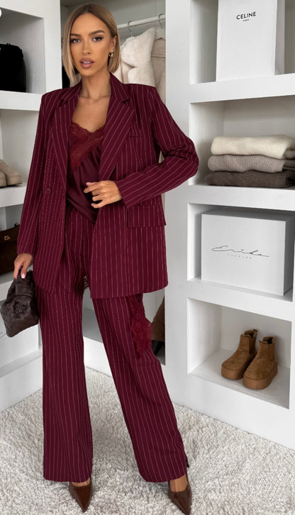 Tailleur Erika sofisticato dal carattere deciso, perfetto per chi ama un’eleganza contemporanea con un tocco sensuale. Il set è composto da blazer doppio petto gessato con top in pizzo e pantalone coordinato a gamba ampia