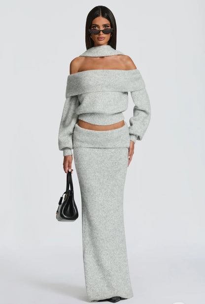 Set BIANCA composto da maglia off-shoulder e gonna lunga a sirena. Realizzato in morbida maglia calda, avvolge la silhouette con eleganza e comfort. Il design con collo ad anello e spalle scoperte aggiunge un tocco sofisticato e sensuale