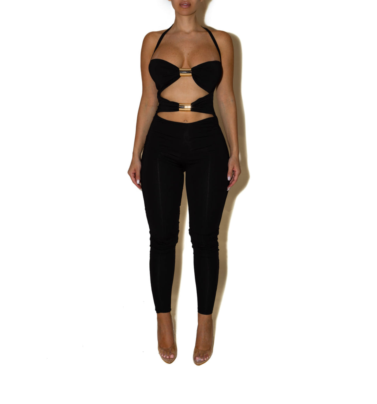 Jumpsuite SCARLETT Un look audace e raffinato che valorizza la silhouette con un design cut-out e dettagli metallici. Il top con inserti dorati e il pantalone a vita alta creano un equilibrio perfetto tra sensualità e stile moderno.