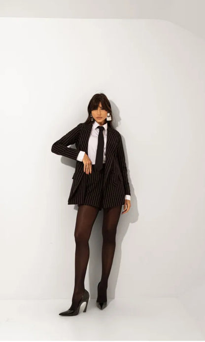 Tailleur Madison outfit dal carattere deciso e sofisticato composto da blazer gessato dal taglio sartoriale e shorts coordinati camicia e cravatta, il design elegante incontra uno stile moderno e urbano, perfetto per creare look raffinati