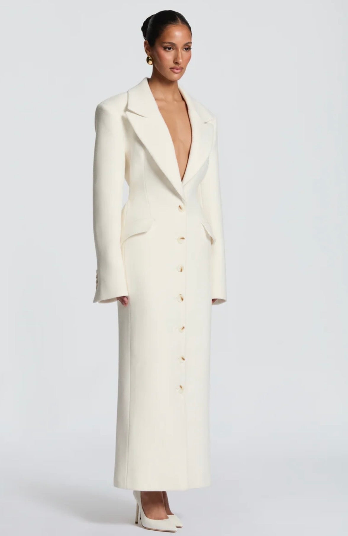 Cappotto ANGELICA lungo in lana, con bottoni frontali e maxi revers a scialle. La linea dritta e sartoriale slancia la figura, mentre il colletto ampio aggiunge un tocco sofisticato. Perfetto per look invernali raffinati, dal giorno alla sera.