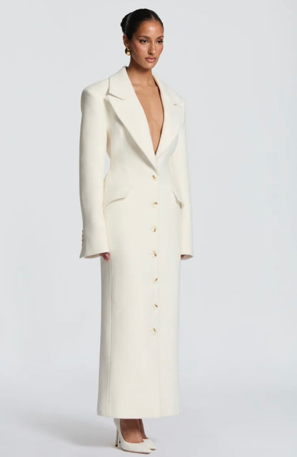Cappotto ANGELICA lungo in lana, con bottoni frontali e maxi revers a scialle. La linea dritta e sartoriale slancia la figura, mentre il colletto ampio aggiunge un tocco sofisticato. Perfetto per look invernali raffinati, dal giorno alla sera.