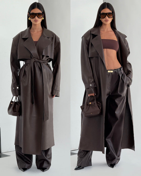 Completo ANITA elegante in eco-pelle nera composto da cappotto lungo con cintura e pantaloni a vita alta dal taglio ampio. Un look deciso e sofisticato, perfetto per chi ama uno stile contemporaneo e audace.