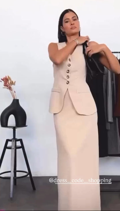 Tailleur ANTONELLA elegante in stile sartoriale è composto da un gilet senza maniche con scollo a V e chiusura a bottoni frontali. La gonna lunga e dritta si abbina perfettamente al gilet, creando un look sofisticato e minimalista