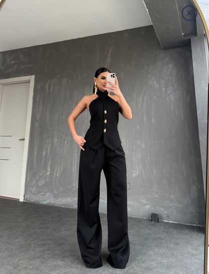 Setcord CRISTINA  composto da un top senza maniche con collo all'americana e pantaloni a gamba larga. Il top presenta una chiusura frontale con tre bottoni dorati