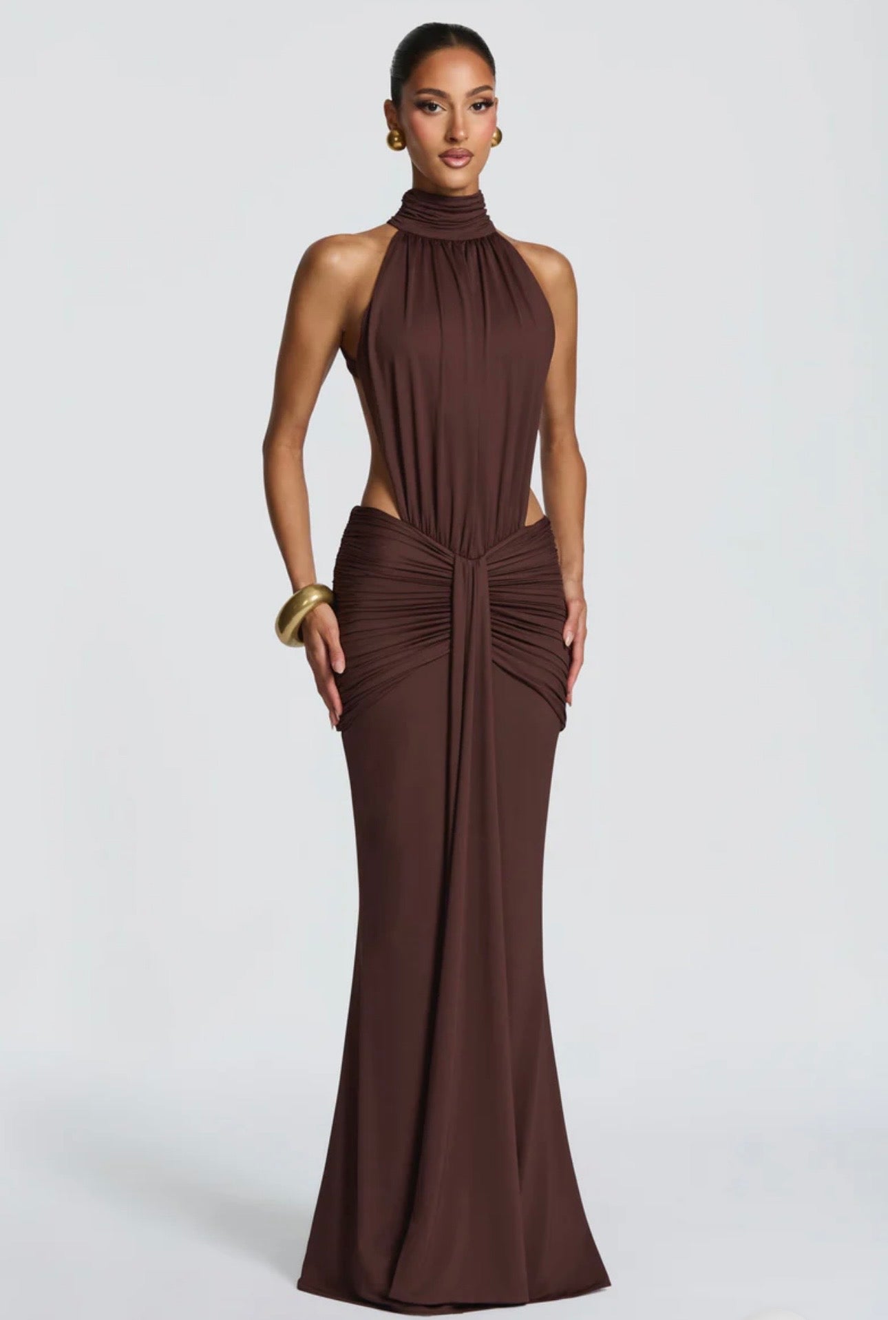 Abito Sofia Caratterizzato da una silhouette a sirena che valorizza le forme, questo modello unisce un sofisticato collo alto a un audace gioco di drappeggi e intagli cut-out sui fianchi.