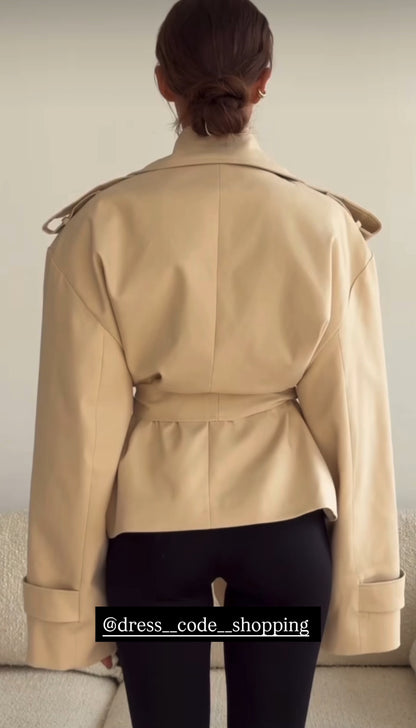 Trench ERIKA Un capo intramontabile dal taglio moderno. Questo trench corto presenta revers ampi, dettagli strutturati e cintura in vita per valorizzare la silhouette. Perfetto da indossare su look casual o eleganti, ideale per la mezza stagione