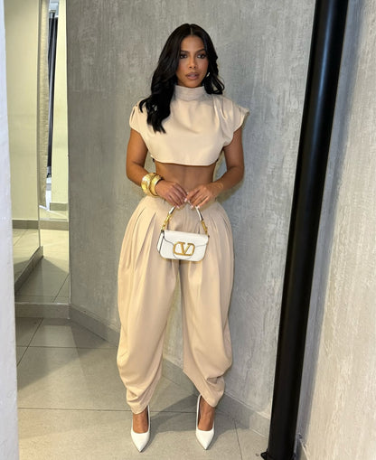 Set PRAGA Completo elegante composto da crop top a collo alto e pantaloni palazzo morbidi con pieghe frontali. Realizzato in tessuto fluido e leggero per una vestibilità confortevole e chic.