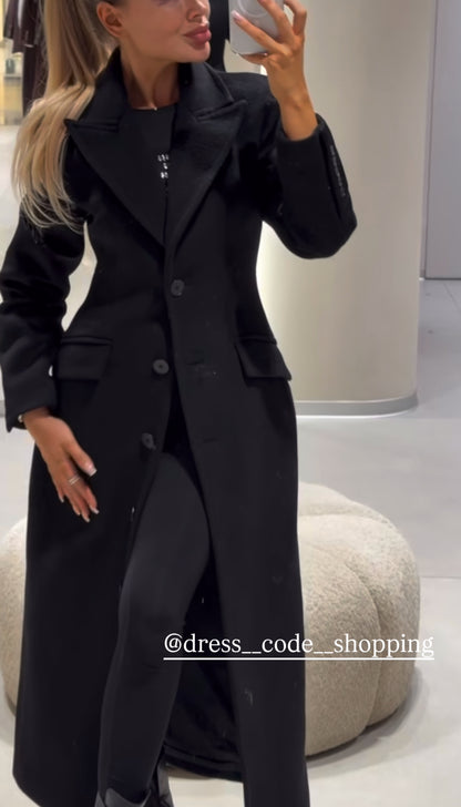 Cappotto ANGELICA lungo grigio in lana, con bottoni frontali e maxi revers a scialle. La linea dritta e sartoriale slancia la figura, mentre il colletto ampio aggiunge un tocco sofisticato. Perfetto per look invernali raffinati, dal giorno alla sera.