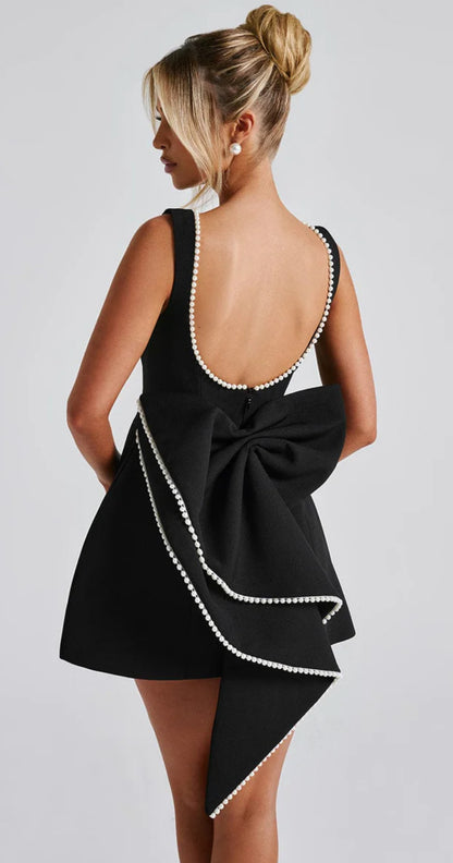 Mini Dress ALESSIA caratterizzato da un design sofisticato e femminile. Presenta una scollatura profonda sulla schiena, impreziosita da un bordo di perline che segue il profilo delle spalline e il décolleté posteriore…