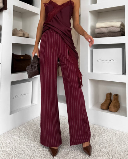 Tailleur Erika sofisticato dal carattere deciso, perfetto per chi ama un’eleganza contemporanea con un tocco sensuale. Il set è composto da blazer doppio petto gessato con top in pizzo e pantalone coordinato a gamba ampia