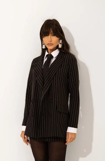 Tailleur Madison outfit dal carattere deciso e sofisticato composto da blazer gessato dal taglio sartoriale e shorts coordinati camicia e cravatta, il design elegante incontra uno stile moderno e urbano, perfetto per creare look raffinati