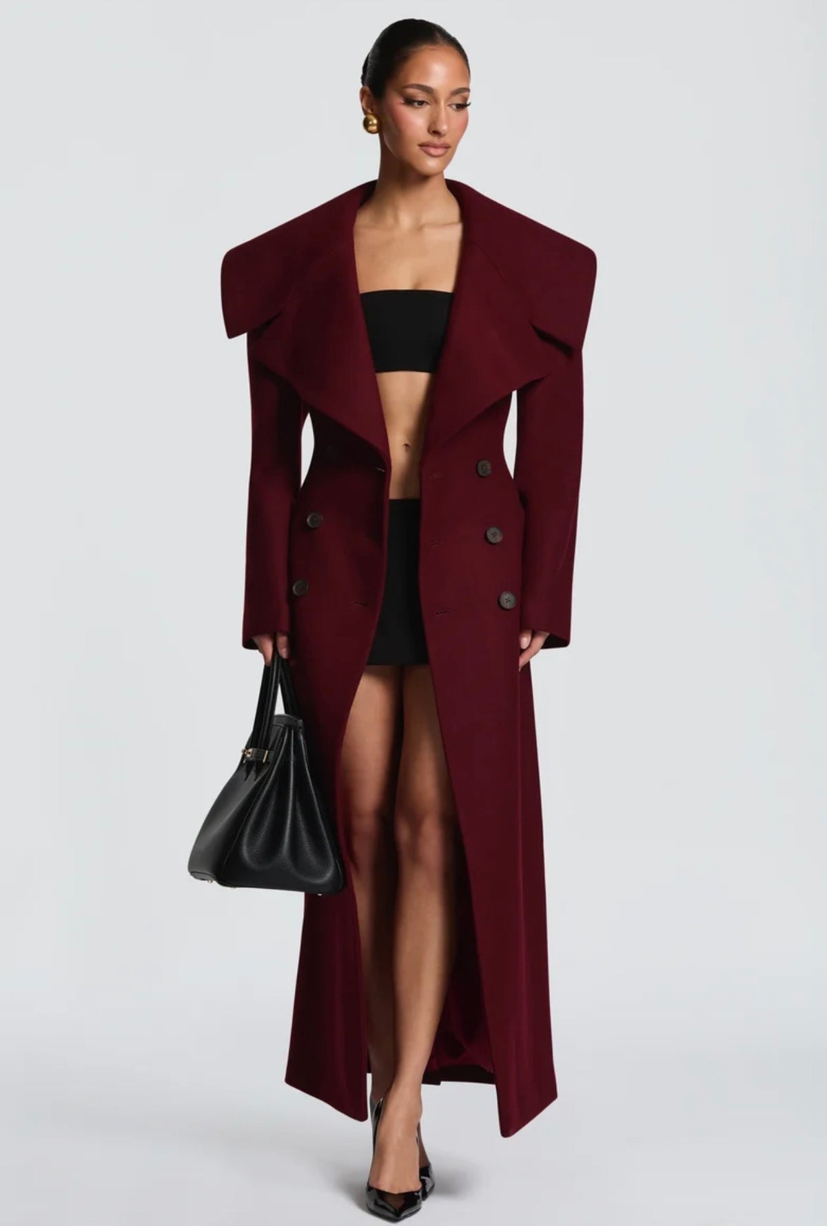 Cappotto Lungo Sartoriale con Maximantellina Un capospalla scenografico e di classe che ridefinisce l'eleganza invernale. Caratterizzato da un'ampia mantellina sulle spalle e una silhouette clessidra accentuata dal punto vita segnato.