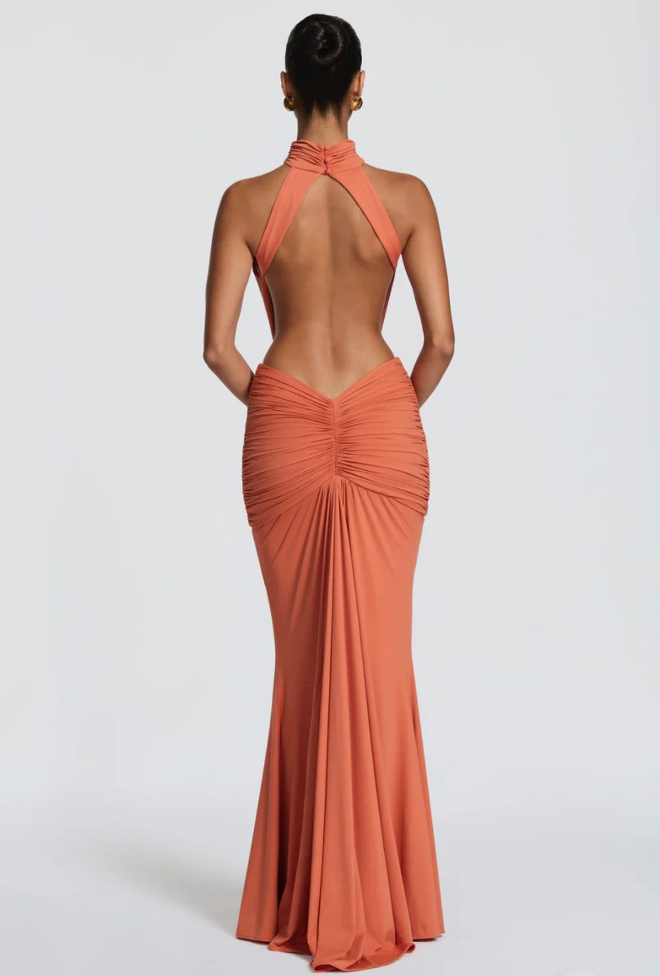 Abito Sofia Caratterizzato da una silhouette a sirena che valorizza le forme, questo modello unisce un sofisticato collo alto a un audace gioco di drappeggi e intagli cut-out sui fianchi.