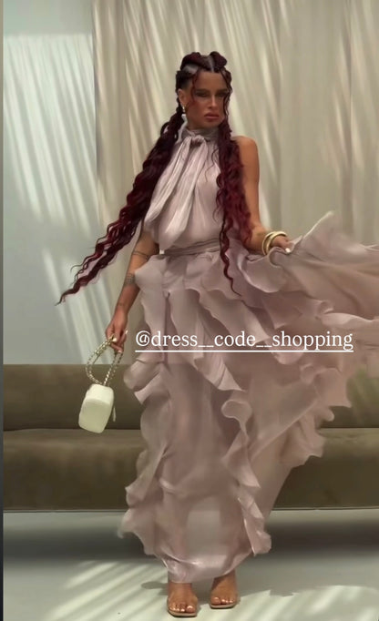 Abito Rouches maxi dress con scollo all'americana, collo con fiocco e gonna a cascata di rouches multistrato pensato per chi vuole essere al centro della scena senza sforzo. La silhouette fluida e il tessuto leggero lo rendono perfetto