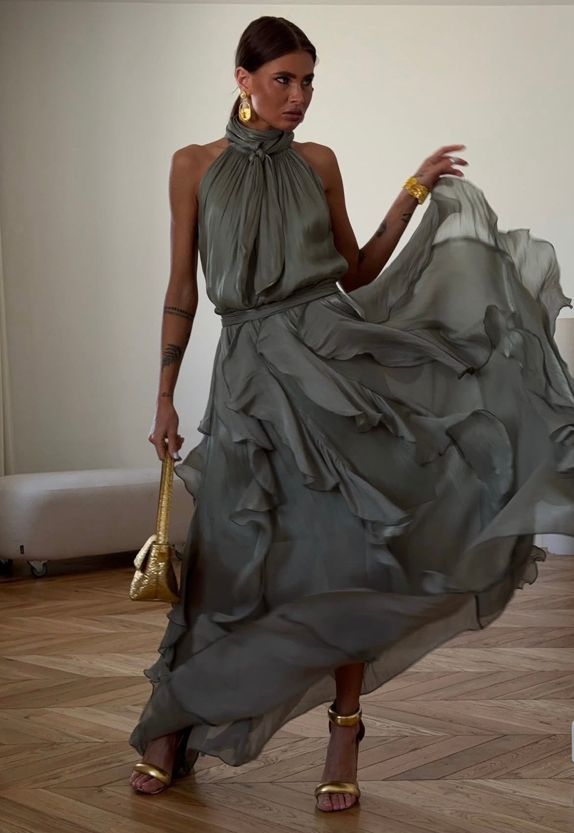 Abito Rouches maxi dress con scollo all'americana, collo con fiocco e gonna a cascata di rouches multistrato pensato per chi vuole essere al centro della scena senza sforzo. La silhouette fluida e il tessuto leggero lo rendono perfetto