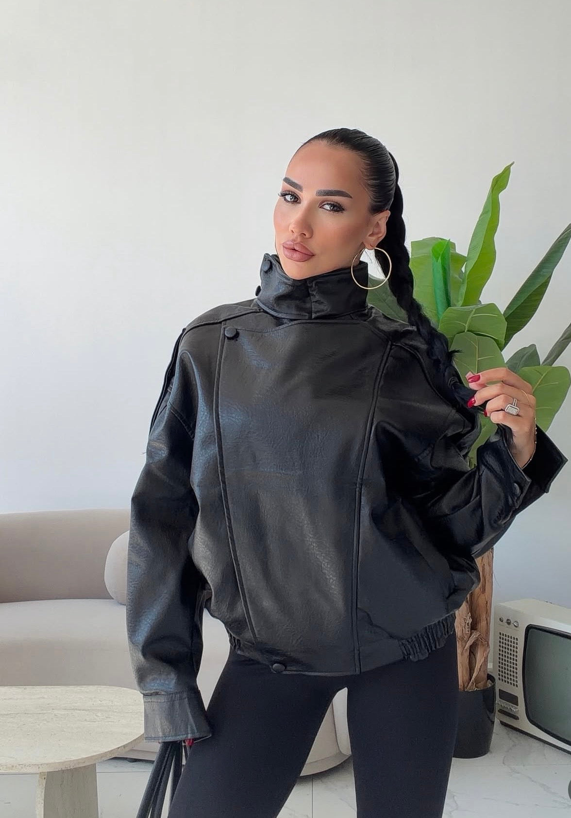 Giacca Biker Oversize in pelle Caratterizzata da una silhouette strutturata con spalle scese e un collo alto avvolgente con cinturino, è il capo spalla perfetto per completare i tuoi outfit streetwear ed eleganti con un tocco audace.