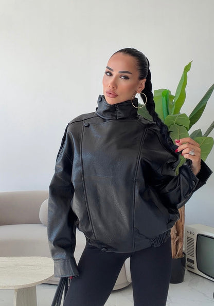 Giacca Biker Oversize in pelle Caratterizzata da una silhouette strutturata con spalle scese e un collo alto avvolgente con cinturino, è il capo spalla perfetto per completare i tuoi outfit streetwear ed eleganti con un tocco audace.