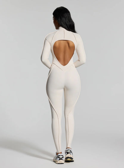 Jumpsuite EMY aderente con schiena scoperta, pensata per valorizzare la silhouette con un effetto shaping. Il tessuto elasticizzato ad alta compressione modella le forme