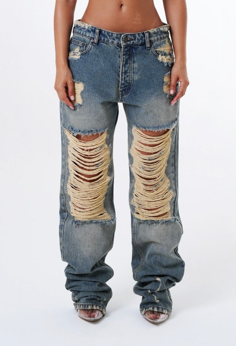 Jeans Baggy "Bronx" Distressed Ispirazione urban e carattere deciso per i jeans "Bronx". Un modello streetwear d'impatto caratterizzato da un lavaggio denim vintage e maxi strappi frontali con lavorazione a trama sfilacciata.