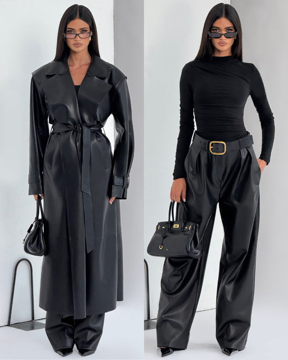 Completo ANITA elegante in eco-pelle nera composto da cappotto lungo con cintura e pantaloni a vita alta dal taglio ampio. Un look deciso e sofisticato, perfetto per chi ama uno stile contemporaneo e audace.