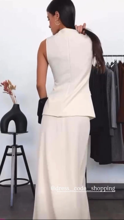 Tailleur ANTONELLA elegante in stile sartoriale è composto da un gilet senza maniche con scollo a V e chiusura a bottoni frontali. La gonna lunga e dritta si abbina perfettamente al gilet, creando un look sofisticato e minimalista