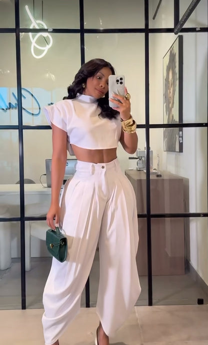 Set PRAGA Completo elegante composto da crop top a collo alto e pantaloni palazzo morbidi con pieghe frontali. Realizzato in tessuto fluido e leggero per una vestibilità confortevole e chic.