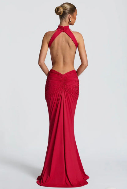 Abito Sofia Caratterizzato da una silhouette a sirena che valorizza le forme, questo modello unisce un sofisticato collo alto a un audace gioco di drappeggi e intagli cut-out sui fianchi.