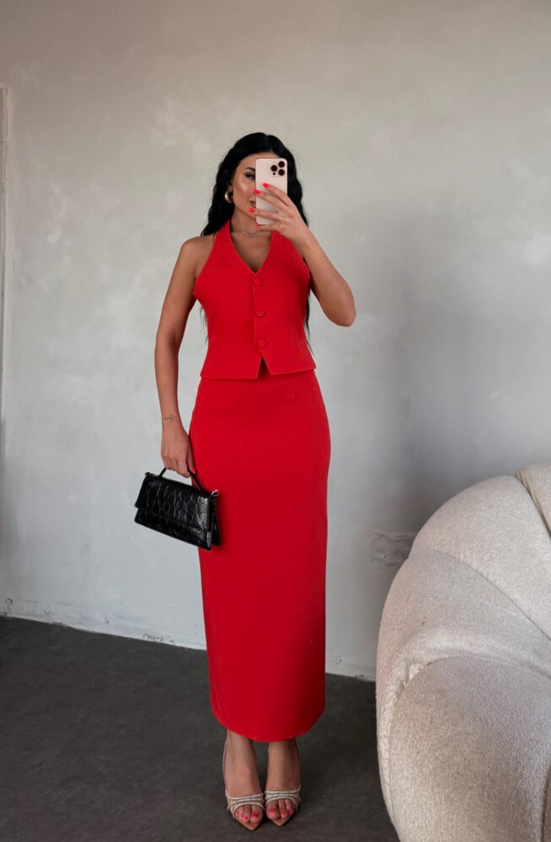 Set ZAIRA indossa un elegante completo bianco composto da un top senza maniche con bottoni e scollo a V, insieme a una gonna a matita lunga fino alla caviglia. Il tessuto di alta qualità