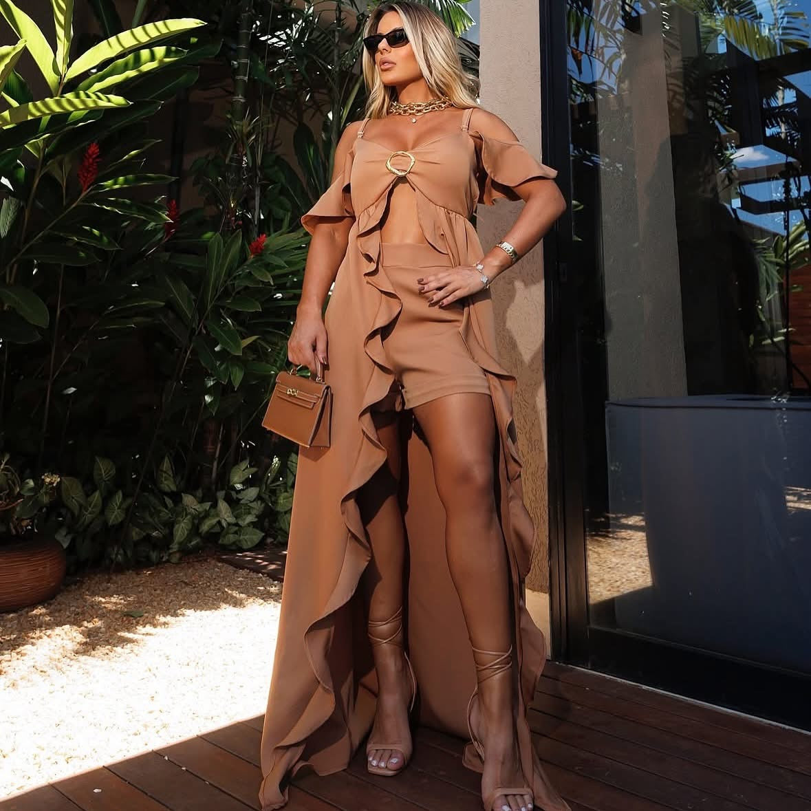Set Ludmilla outfit elegante stile boho-chic. Il look è composto da un completo top con spalle scoperte e nodo centrale decorato con un anello dorato, abbinato a pantaloncini a vita alta dello stesso colore e tessuto.