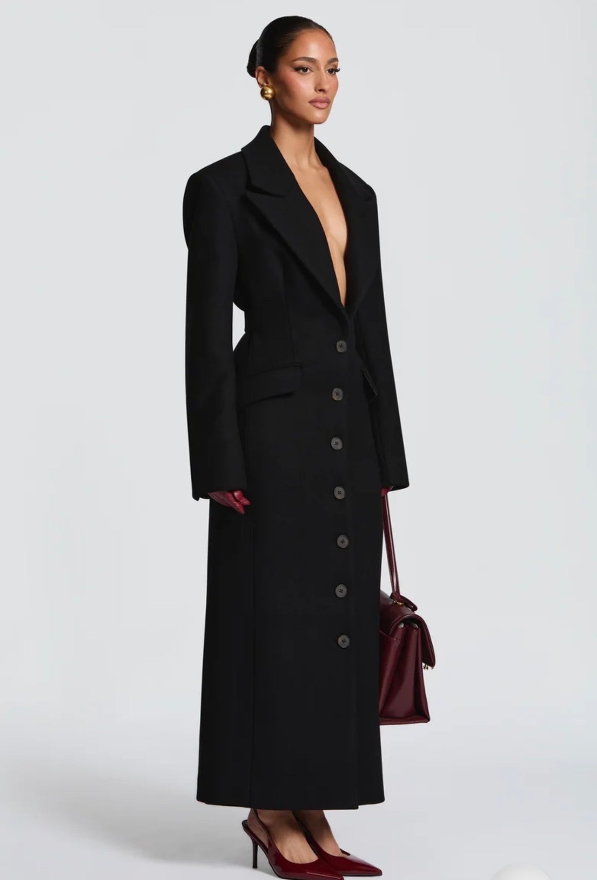 Cappotto ANGELICA lungo in lana, con bottoni frontali e maxi revers a scialle. La linea dritta e sartoriale slancia la figura, mentre il colletto ampio aggiunge un tocco sofisticato. Perfetto per look invernali raffinati, dal giorno alla sera.
