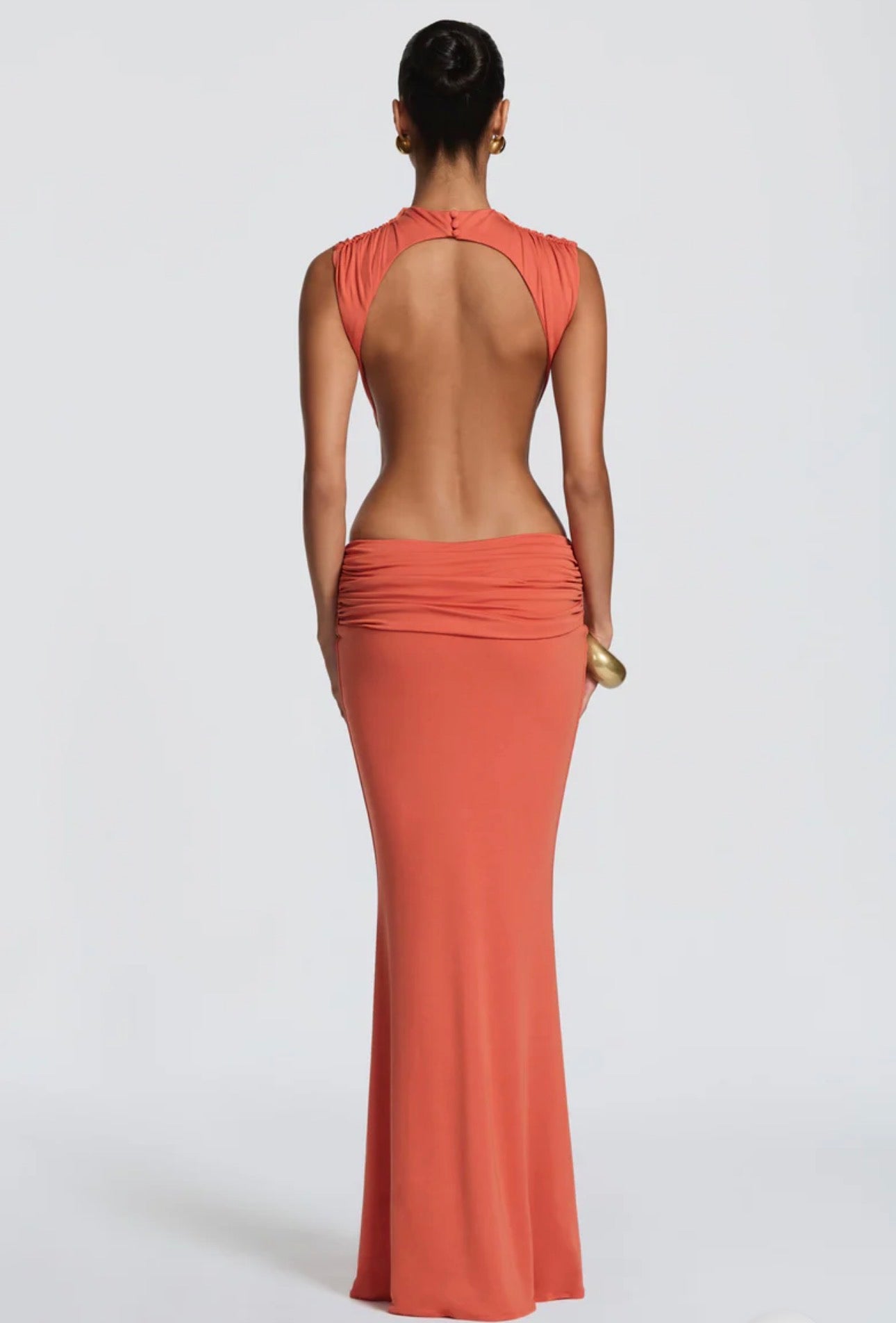 Abito Sahara maxi aderente  con design cut-out laterale che scolpisce la silhouette. Il collo alto crea un raffinato contrasto con le ampie aperture sui fianchi e la schiena scoperta, per un effetto sensuale ma sofisticato.