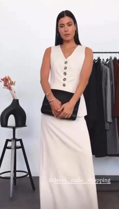 Tailleur ANTONELLA elegante in stile sartoriale è composto da un gilet senza maniche con scollo a V e chiusura a bottoni frontali. La gonna lunga e dritta si abbina perfettamente al gilet, creando un look sofisticato e minimalista