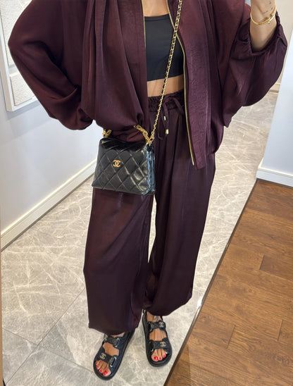 Coordinato PRISCILLA Completo elegante e versatile in tessuto satinato composto da giacca leggera oversize con zip e pantaloni ampi a vita alta con coulisse. Perfetto per look chic e confortevoli, dal giorno alla sera.