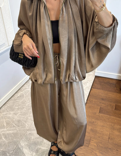 Coordinato PRISCILLA Completo elegante e versatile in tessuto satinato composto da giacca leggera oversize con zip e pantaloni ampi a vita alta con coulisse. Perfetto per look chic e confortevoli, dal giorno alla sera.