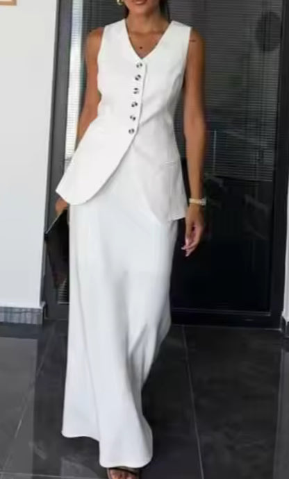 Tailleur ANTONELLA elegante in stile sartoriale è composto da un gilet senza maniche con scollo a V e chiusura a bottoni frontali. La gonna lunga e dritta si abbina perfettamente al gilet, creando un look sofisticato e minimalista