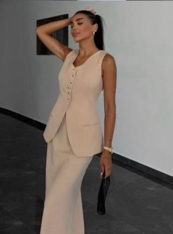 Tailleur ANTONELLA elegante in stile sartoriale è composto da un gilet senza maniche con scollo a V e chiusura a bottoni frontali. La gonna lunga e dritta si abbina perfettamente al gilet, creando un look sofisticato e minimalista