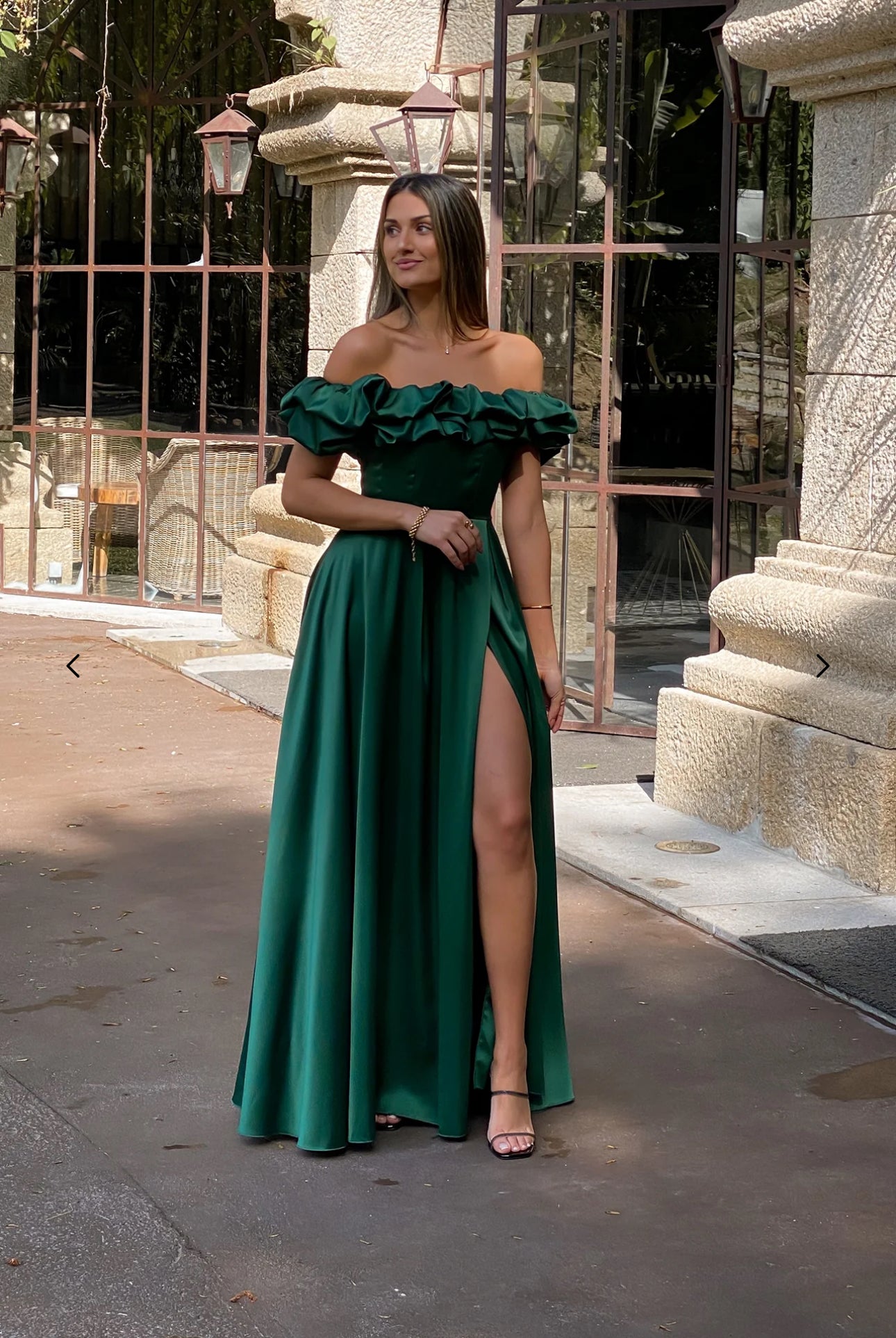 Abito MARYA Elegante abito off-shoulder con corpino arricciato a balze e ampia gonna con spacco laterale.