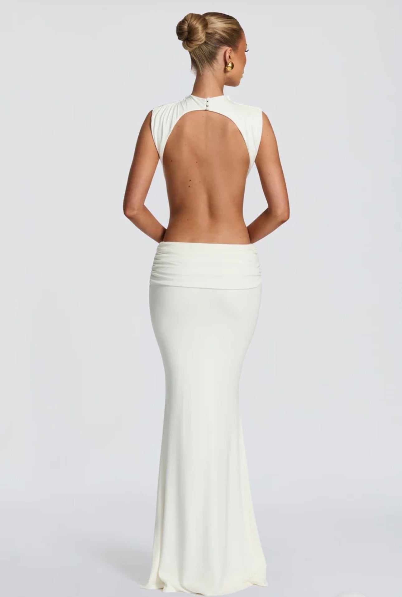 Abito Sahara maxi aderente  con design cut-out laterale che scolpisce la silhouette. Il collo alto crea un raffinato contrasto con le ampie aperture sui fianchi e la schiena scoperta, per un effetto sensuale ma sofisticato.